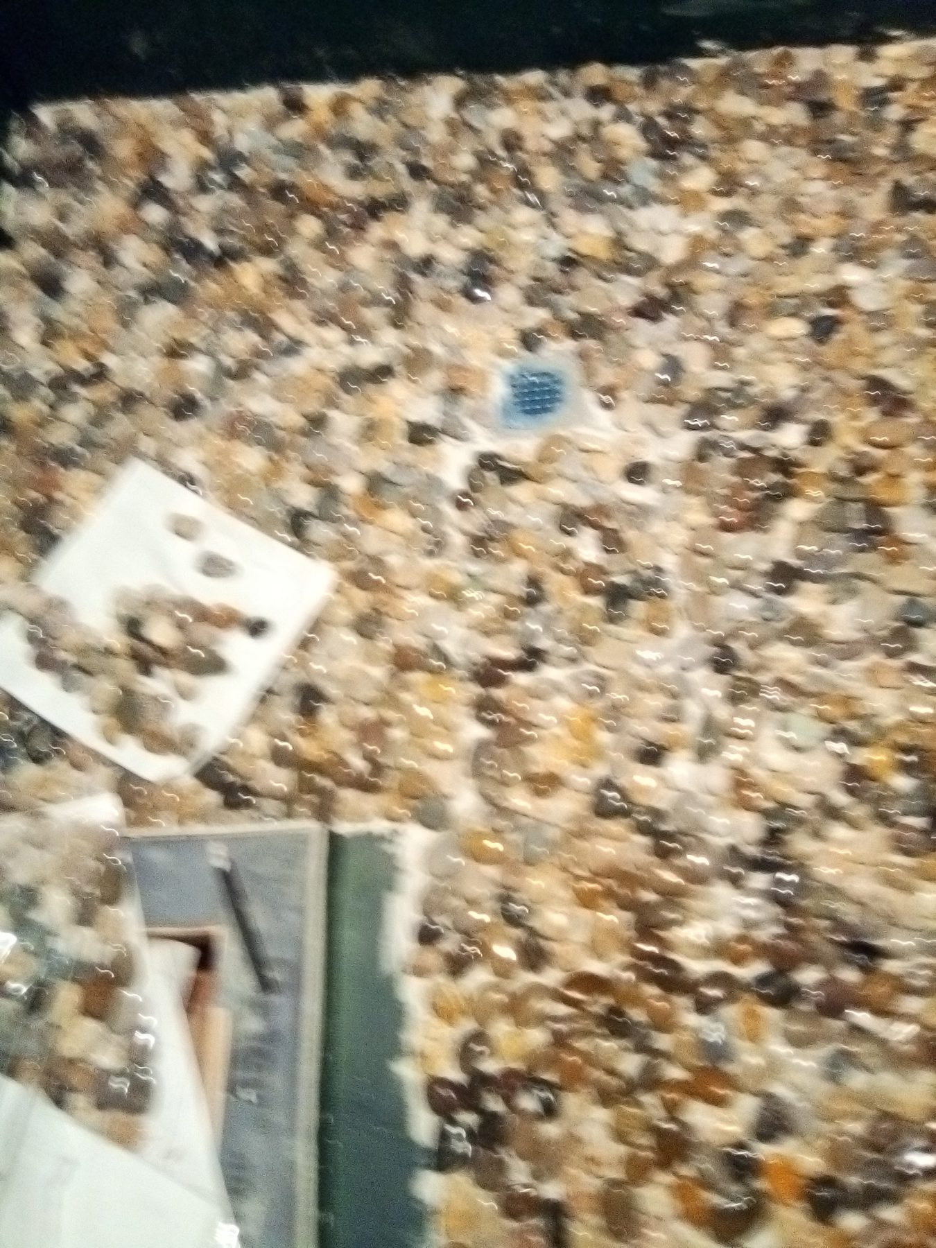 Pebble floor detail around the shower drain.