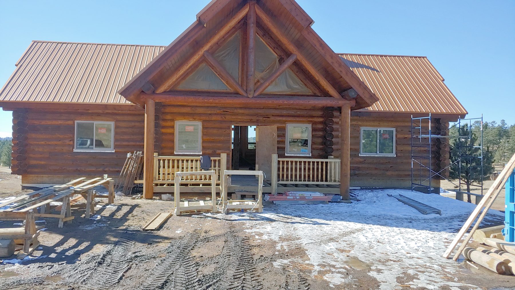 Front elevation with the entry gable and log railings.